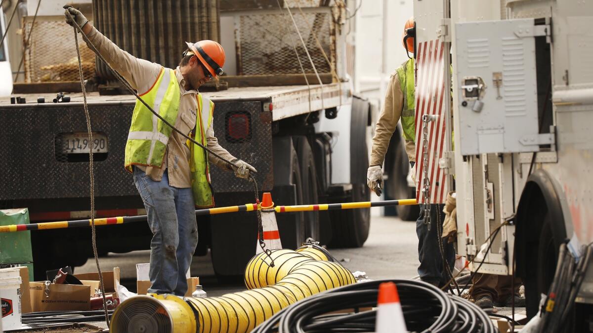 Department of Water and Power crews block South Westmoreland Avenue at 6th Street in Koreatown as they work to restore power to customers Monday.