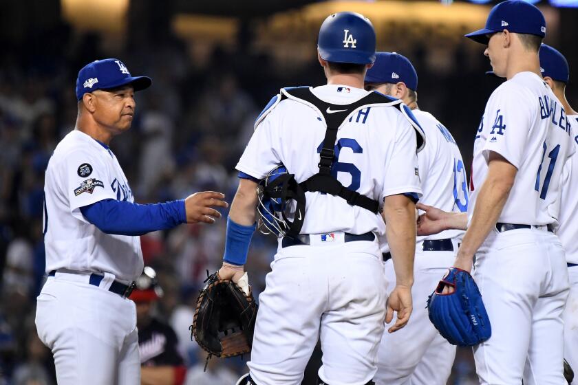 LOS ANGELES, CALIFORNIA OCTOBER 9, 2019-Dodgers manger Dave Roberts pulls pitcher Walker Buehler, right, out of the game in Game 5 of the NLDS at Dodger Stadium Wednesday. (Wally Skalij/Los Angeles Times)