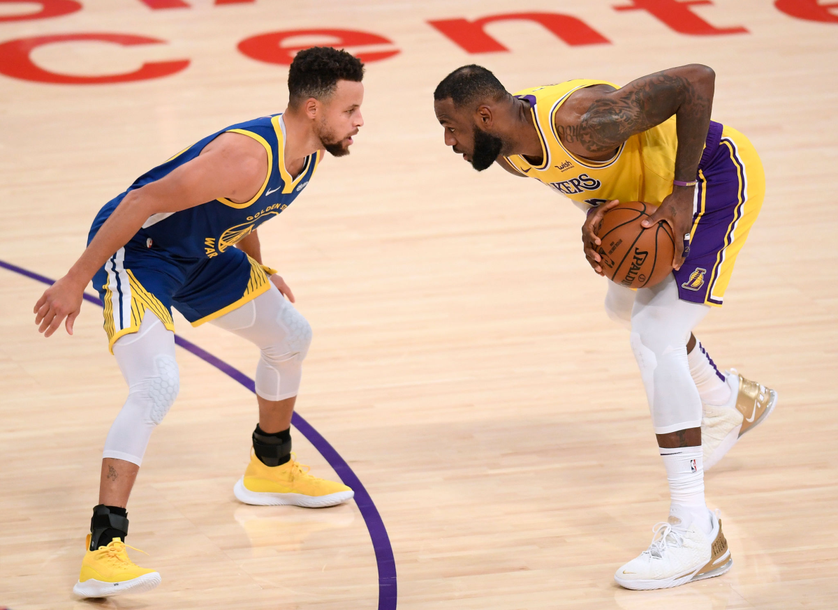 Lakers forward LeBron James controls the ball in front of Golden State Warriors guard Stephen Curry.