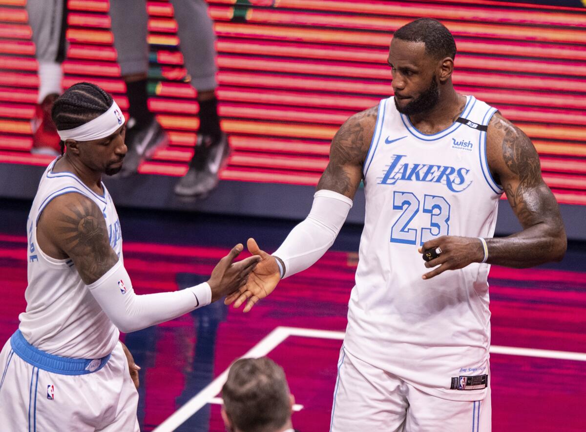 The Lakers' LeBron James, right, and Kentavious Caldwell-Pope celebrate a win over the Indiana Pacers on May 15, 2021. 