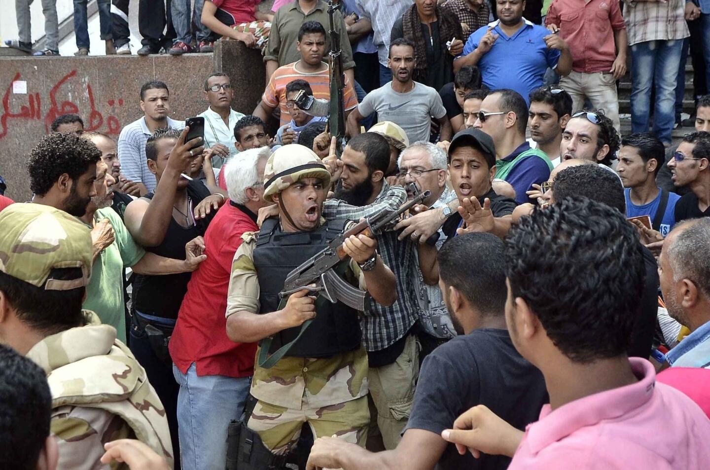 An Egyptian soldier points his weapon as he helps an Islamist man leave Cairo's Al Fatih mosque, where protesters had been surrounded by security forces and vigilante groups. The standoff ended Saturday after religious leaders intervened.