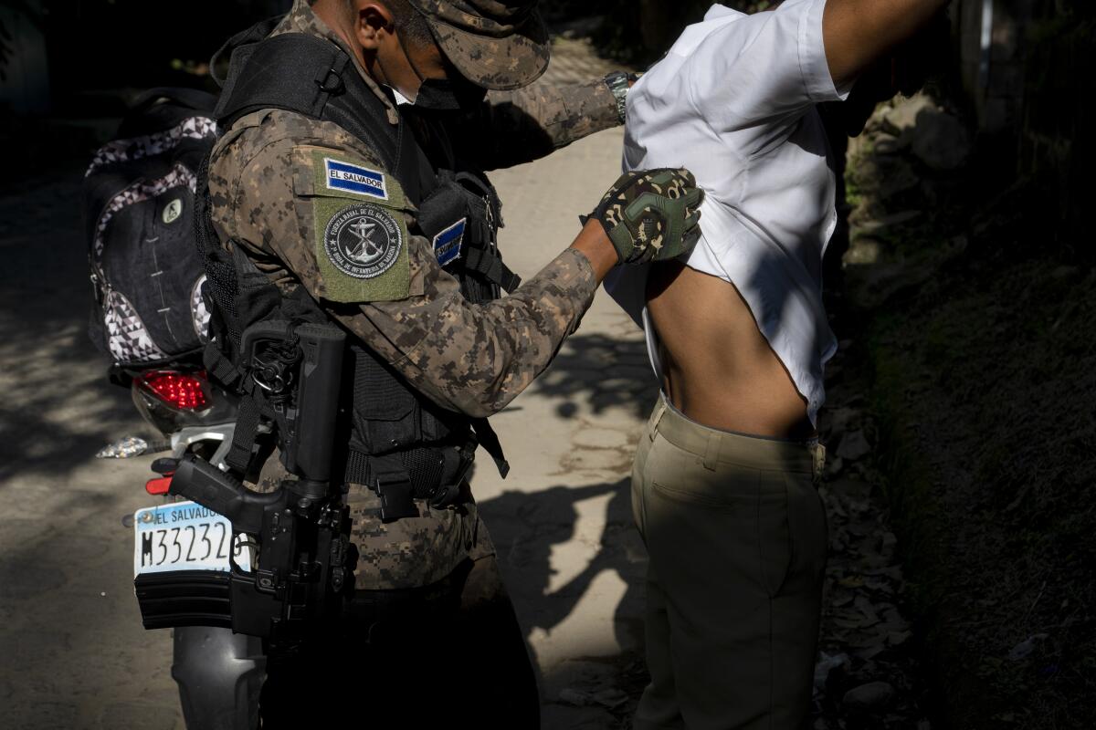 Un soldado registra a un motociclista en un retén en las afueras de Comasagua, El Salvador