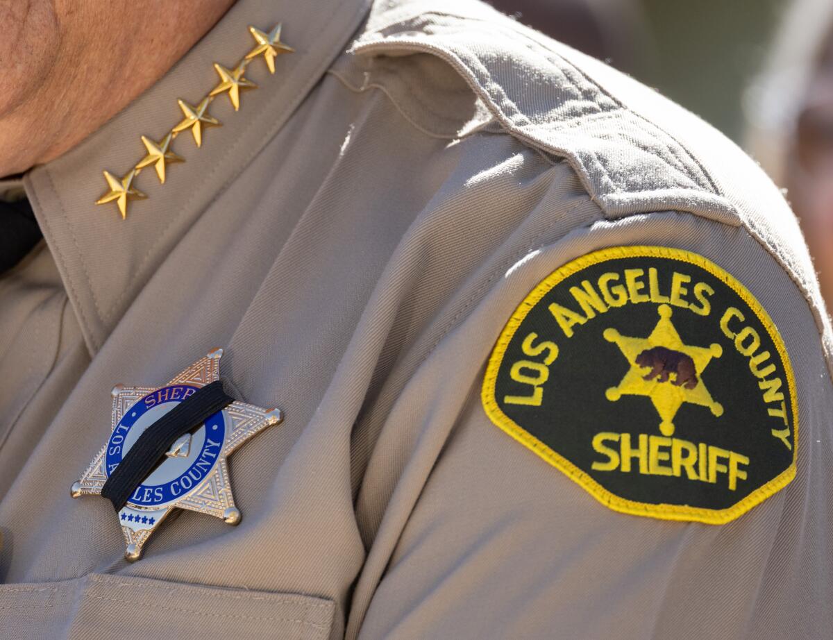Closeup of a sheriff's badge with a black band over it