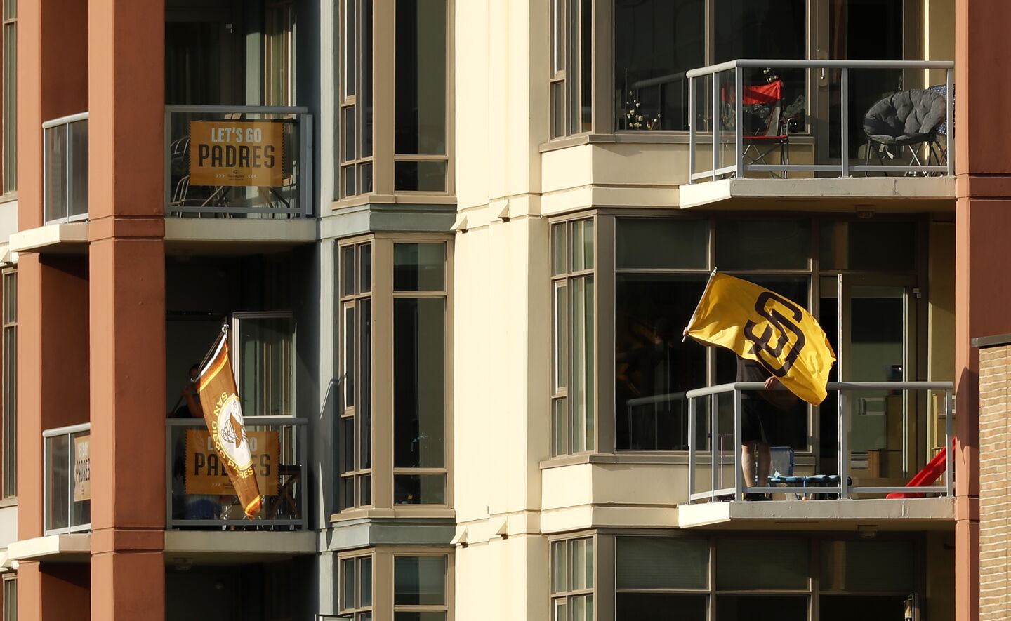 Fans wave flags in nearby buildings as the San Diego Padres play the Colorado Rockies at Petco Park on Wednesday, Sept. 9, 2020.