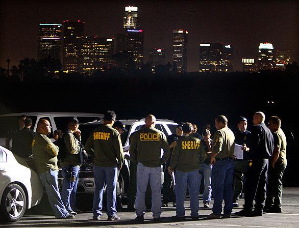 From a command post in Elysian Park, officers of the Los Angeles Police Department, the federal Drug Enforcement Administration and other agencies go over final details before launching an early morning sweep of members of the violent Avenues gang in northeast Los Angeles.