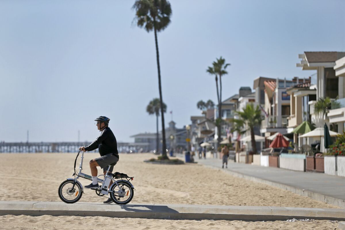 A bicyclist pedals down at Newport Beach.