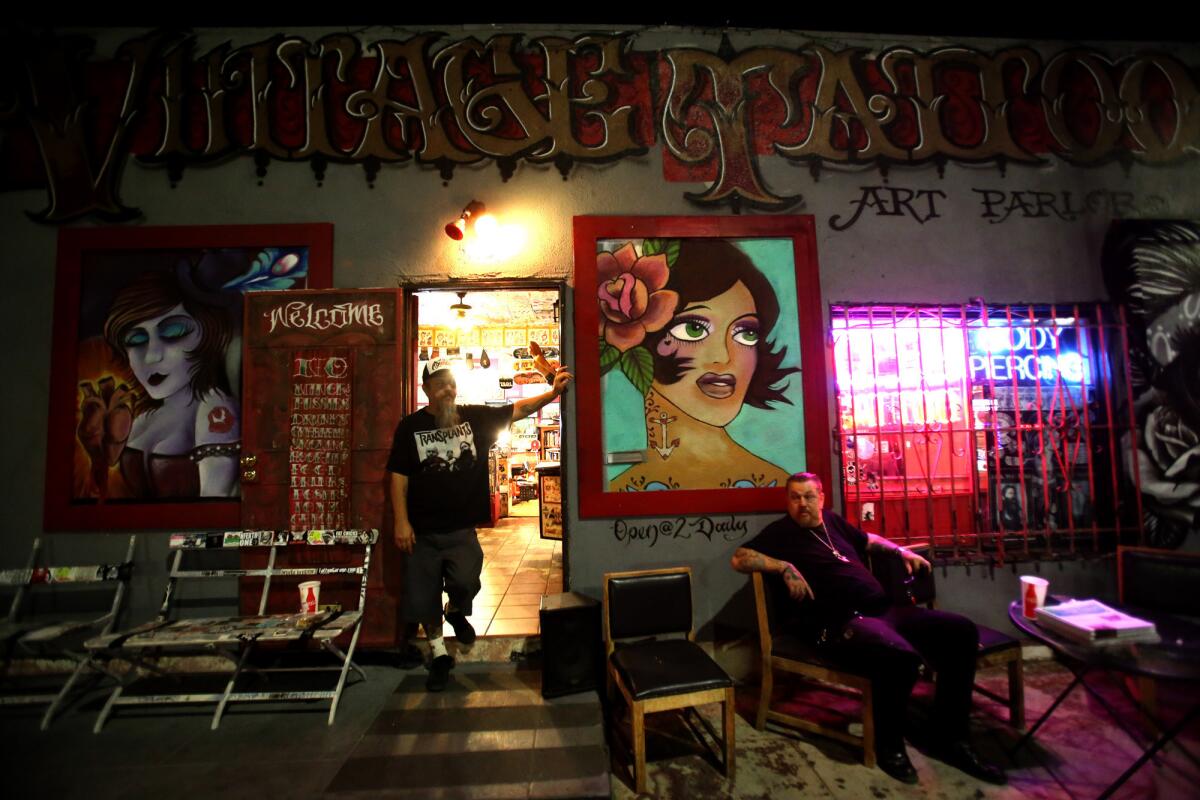 Tattoo artists Odie, left, and his brother Baba, wait for customers in front of Vintage Tattoo Art Parlor on York Avenue in Highland Park.