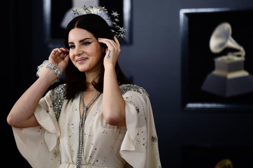 Donning a halo-shaped crown of stars and a white Gucci gown, Lana Del Rey showed her support for the Time’s Up movement with a delicate white rose corsage on her wrist at the 60th Grammy Awards.