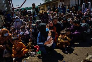 Women and children crouch in the sweltering heat at a Taliban-controlled checkpoint near Abbey Gate, an entrance to the Kabul airport on Aug. 25, 2021. They wait to make their way towards the British military-controlled entrance of the airport. Outside the gates, the bit of U.S.-held territory remaining in the country, bedlam became a daily event. Even those with permission to leave faced crushing crowds and uneasy Taliban fighters using truncheons, sticks, whips, rifle butts and bullets to disperse people around the airport’s environs.