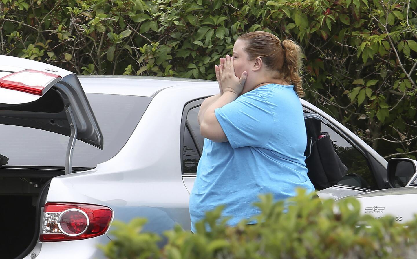 A woman reacts after a deadly shooting Monday, June 5, 2017, in Orlando, Fla. A man who was fired from a Florida awning factory in April returned Monday with a gun and methodically killed several people, then took his own life, authorities said.