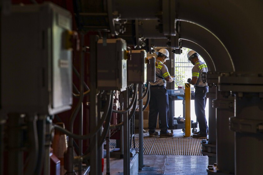 Two workers in a water filtration plant.