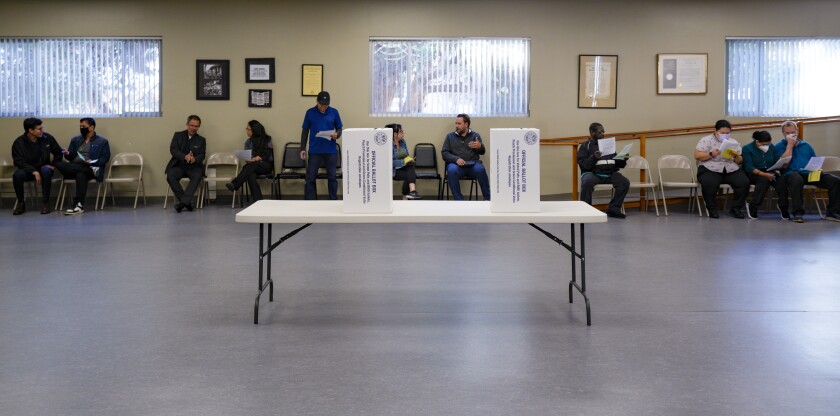 Los miembros del sindicato de tiendas de comestibles revisan sus papeletas antes de emitir su voto.