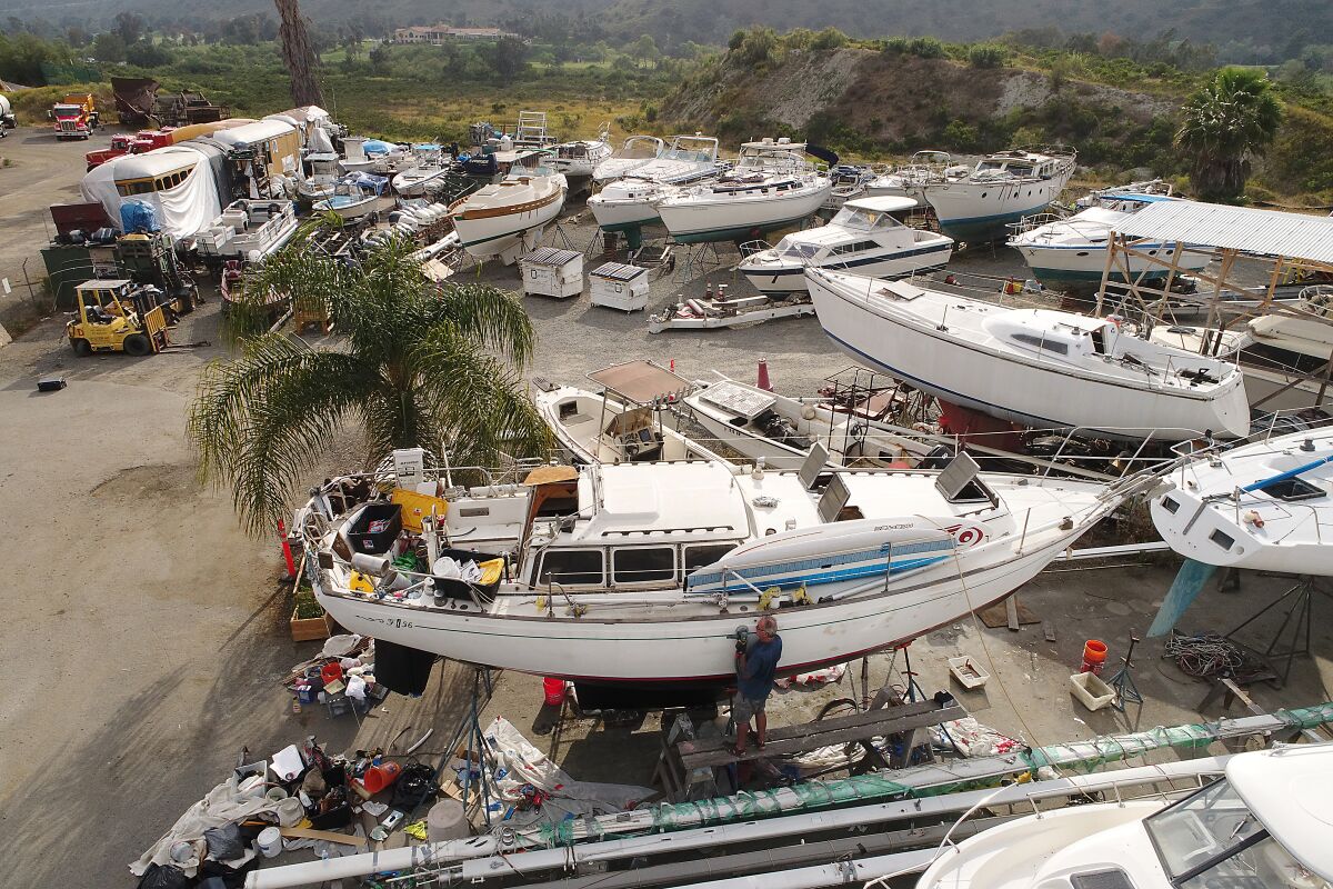  Boat owners at the San Diego Boat Movers yard off Mission Gorge Road work on their individual boats