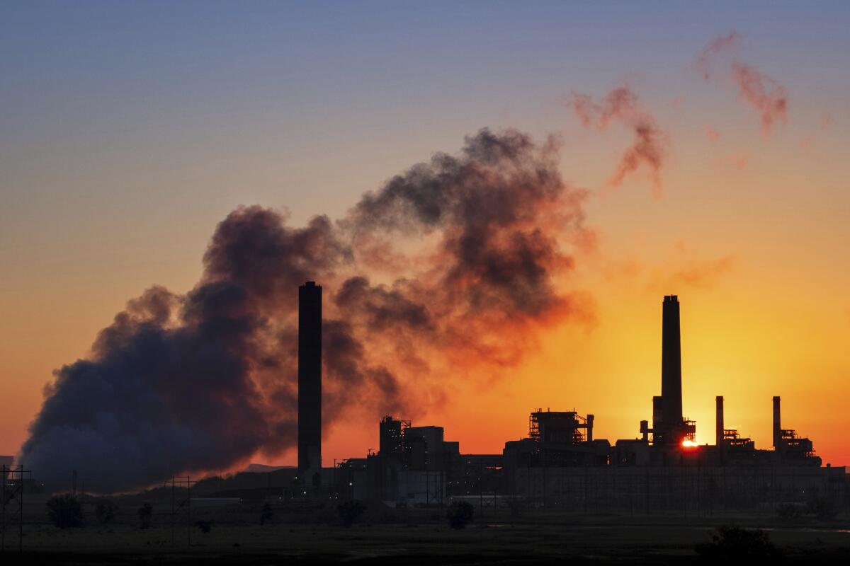 The Dave Johnson coal-fired power plant is silhouetted against the morning sun in Glenrock, Wyo., in July.