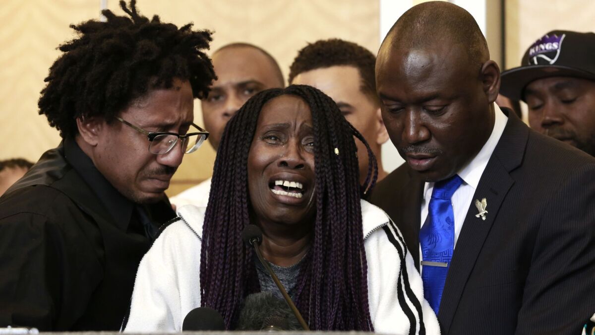 A tearful Sequita Thompson, center, discusses the shooting of her grandson, Stephon Clark, during a news conference on Monday.