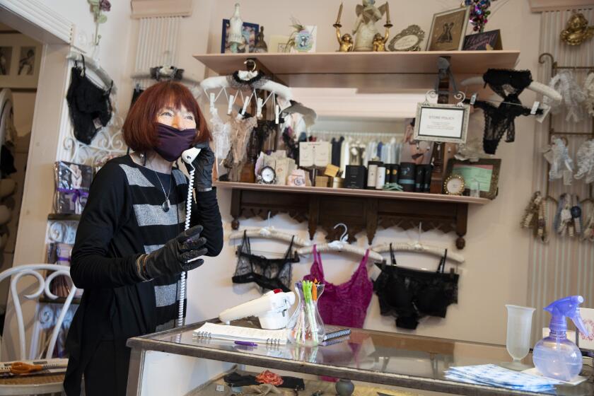 SAN FRANCISCO, CA - MAY 15: Beverly Weinkauf at Toujours Lingerie jots down notes as she listens to a customer's voicemail on Friday, May 15, 2020, in San Francisco, Calif. Weinkauf, who owns the Fillmore district shop, prepared the shop with her goddaughter Katie Reisman to open on Monday after almost two months of shutdown orders due to the coronavirus pandemic. San Francisco on Monday will lift shutdown orders, allowing curbside pickups. (Santiago Mejia/The San Francisco Chronicle via Getty Images)