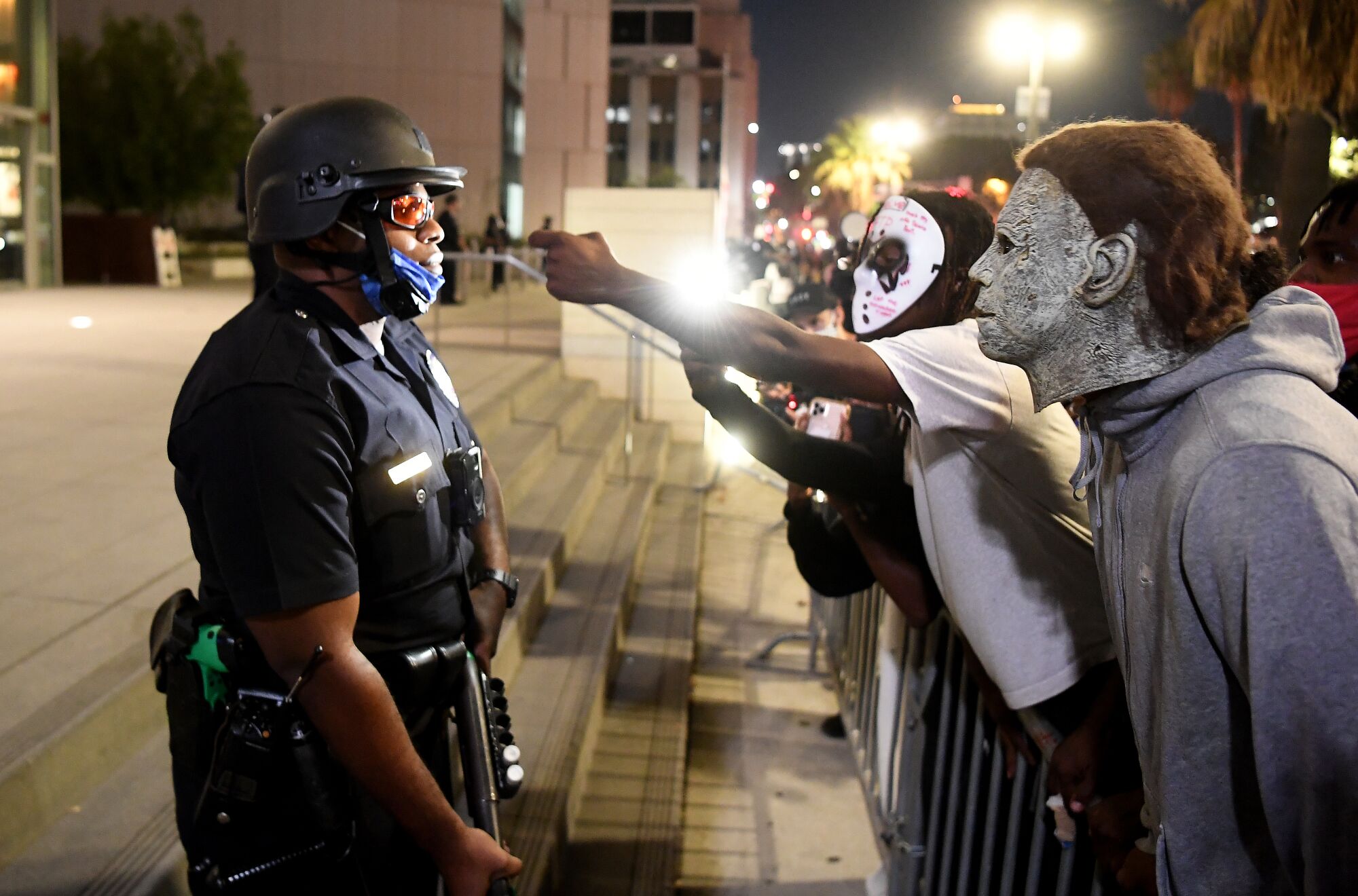 Protestors taunt an LAPD officer outside the headquarters in Los Angeles after a ruling in the Breonna Taylor case