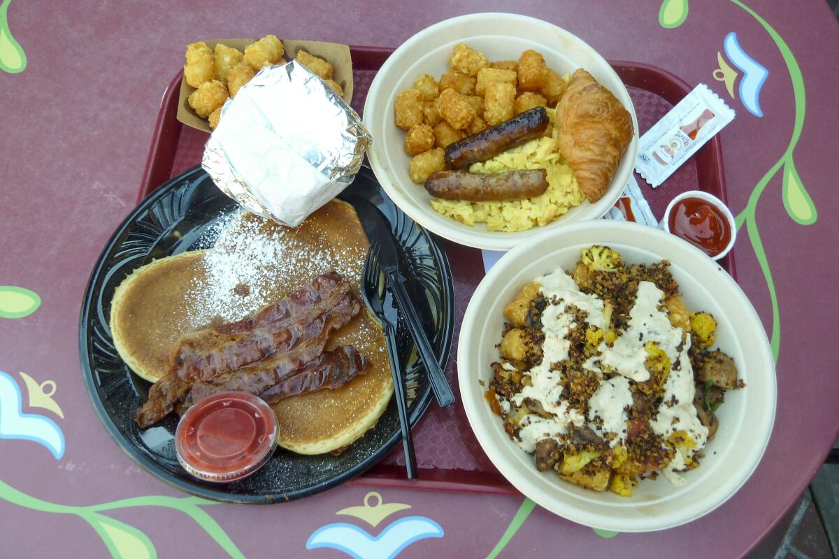 A Mickey-shaped pancake, gourmet breakfast sandwich, Bonjour! Breakfast and Little Town Harvest Bowl from Red Rose Taverne