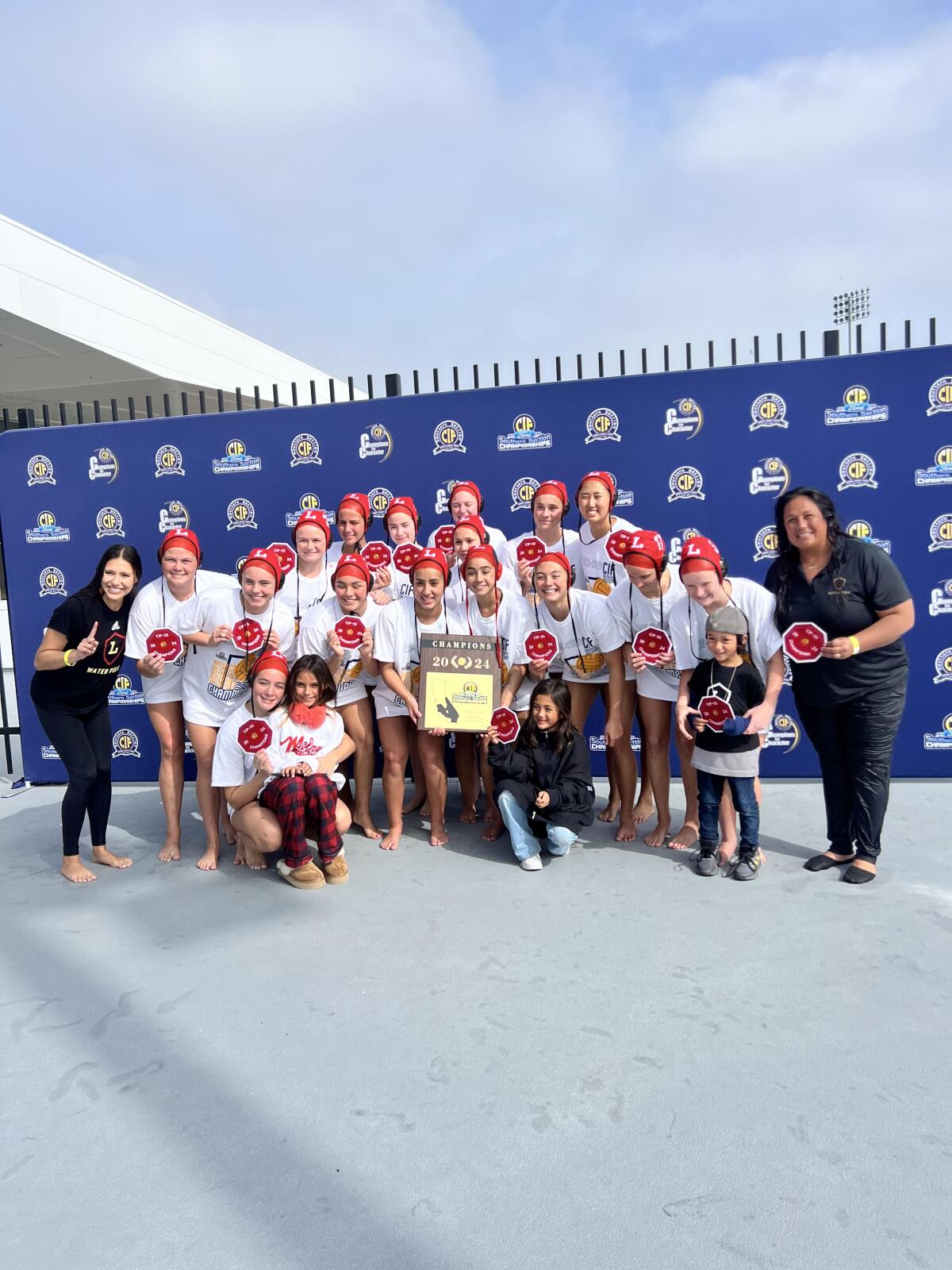 Orange Lutheran's unbeaten girls' water polo team poses for a photo.