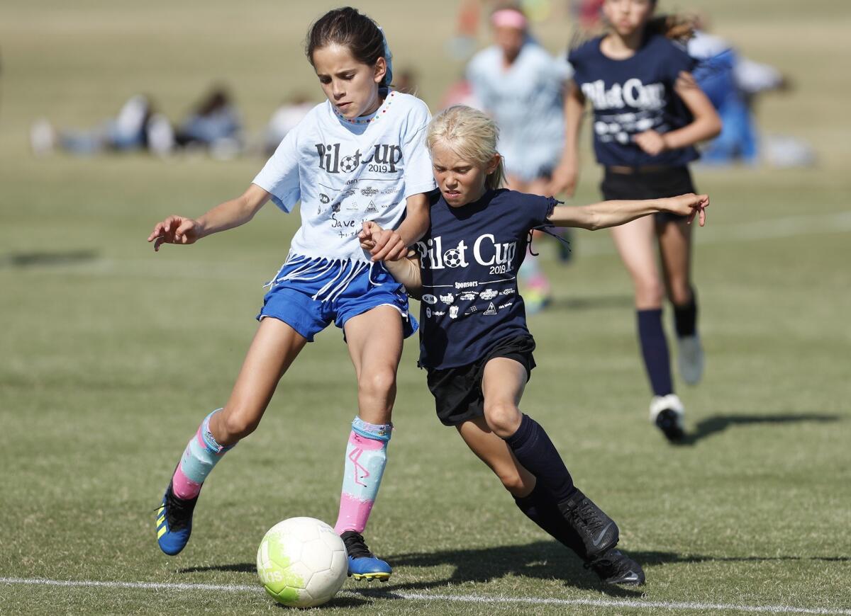 Mariners Elementary's Mia Knox, right, battles for a ball against Andersen's Reese Pluma in a girls' third- and fourth-grade Gold Division pool-play match at the Daily Pilot Cup on Wednesday.