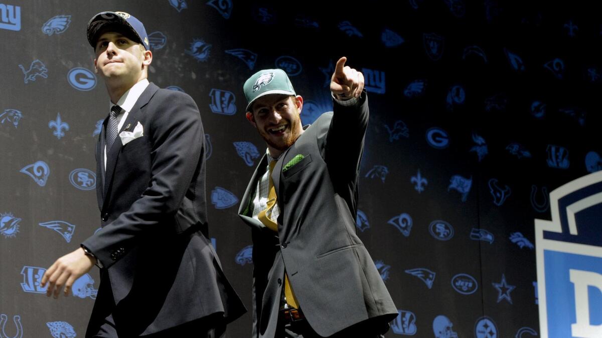 Jared Goff, left, after being selected by the Rams as their number one overall pick and Carson Wentz, after being selected by the Philadelphia Eagles as their top pick in the first round of the 2016 NFL football draft greet fans.