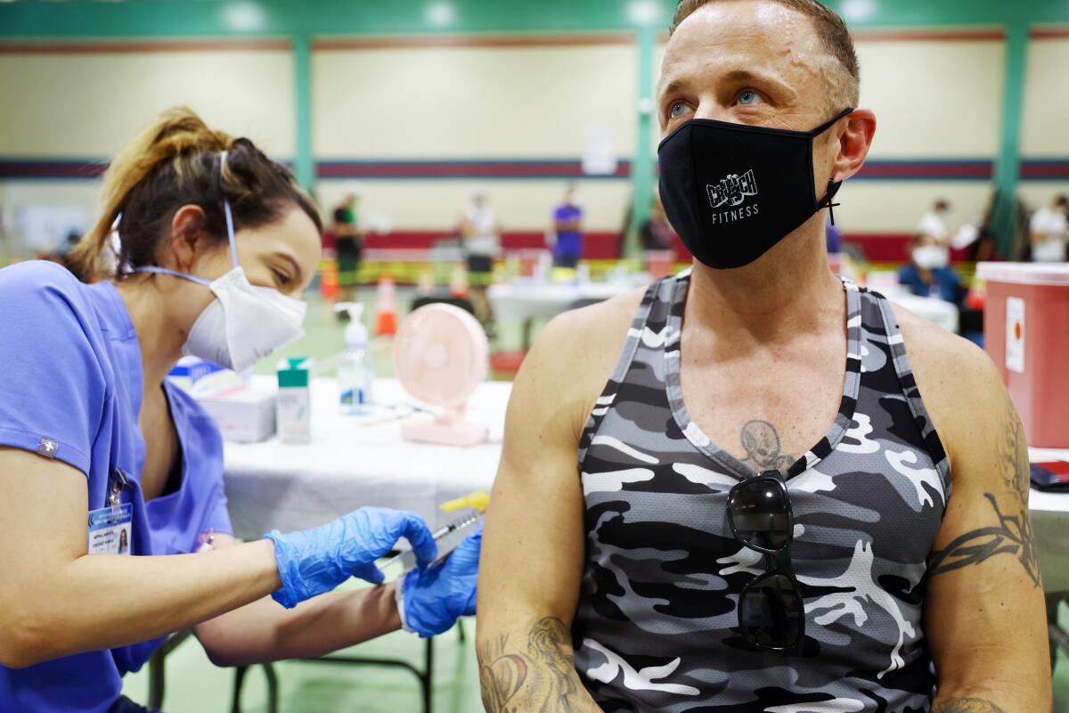 A nurse gives a patient an injection in the arm