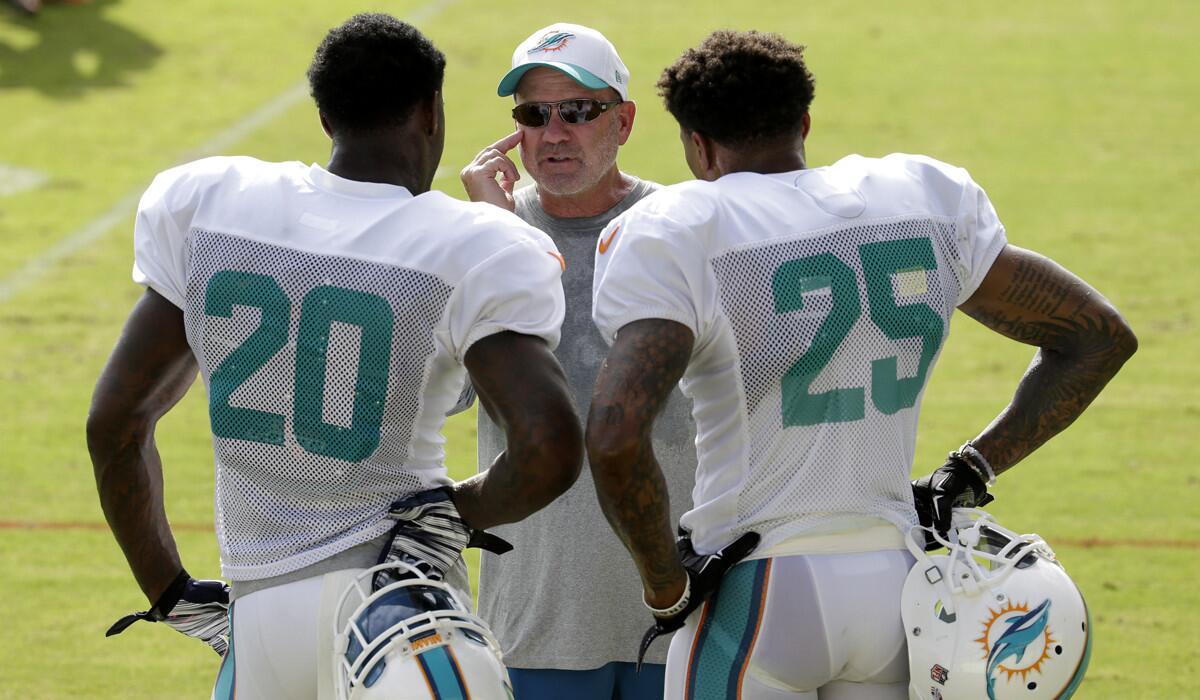 Former Miami Dolphins defensive coordinator Kevin Coyle, center, talks with safety Reshad Jones (20) and safety Louis Delmas (25) during an NFL training camp practice on Aug. 16.