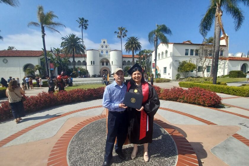 Estephanie Bencomo and her dad,  Ruben Bencomo, taking a picture in front of Hepner Hall at SDSU.