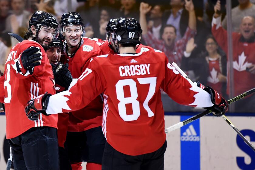 Team Canada defenseman Drew Doughty, left, celebrates with Brad Marchand, second from left, and other teammates after Marchand scored a goal against Team Russia during the third period Saturday.