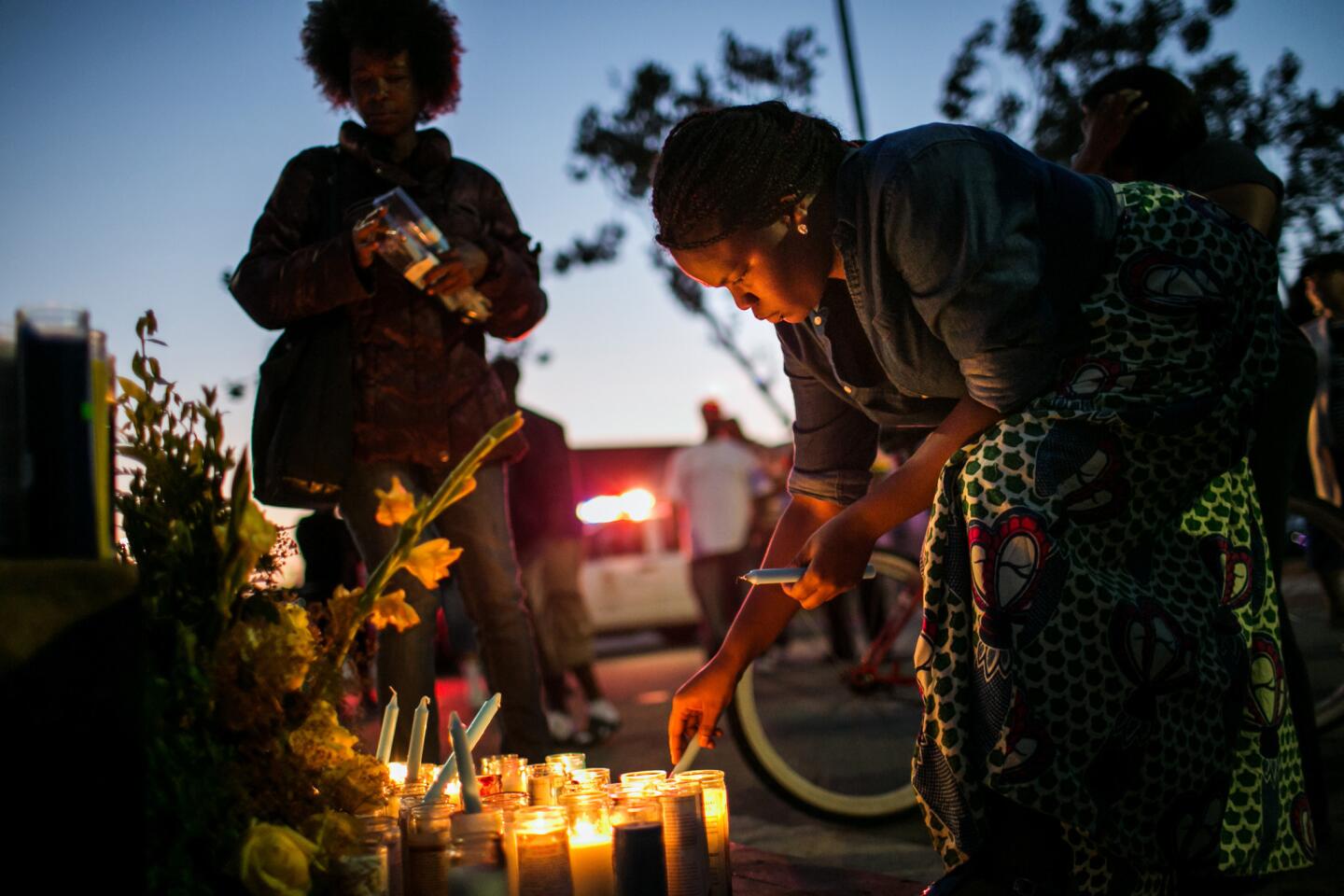 Family members and friends of Marcus McClendon, 52, light candles during a vigil at the site where he was shot and killed.