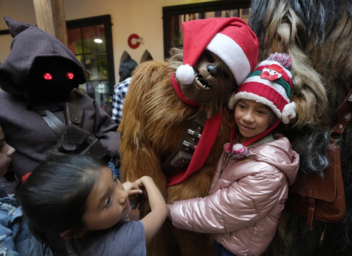 Un wookie de Star Wars posa para la foto con una niña durante un evento solidario