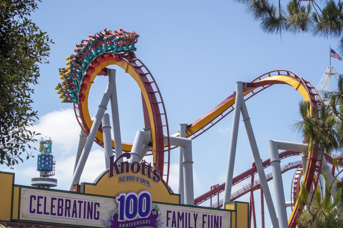 Parkgoers ride a roller coaster near the entrance to Knott's Berry Farm