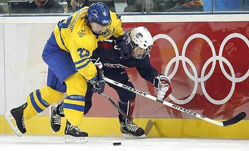 Katie King of the U.S. battles Sweden's Gunilla Andersson for the puck.