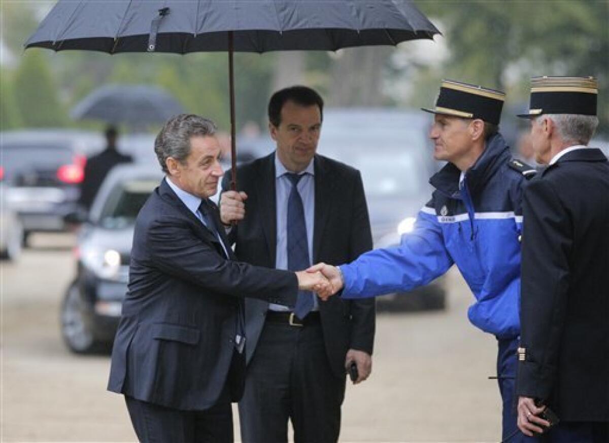 El ex presidente de Francia Nicolas Sarkozy, a la izquierda, estrecha la mano de un gendarme a su llegada para una ceremonia en memoria de las víctimas del terrorismo en París, el lunes 19 de septiembre de 2016.
