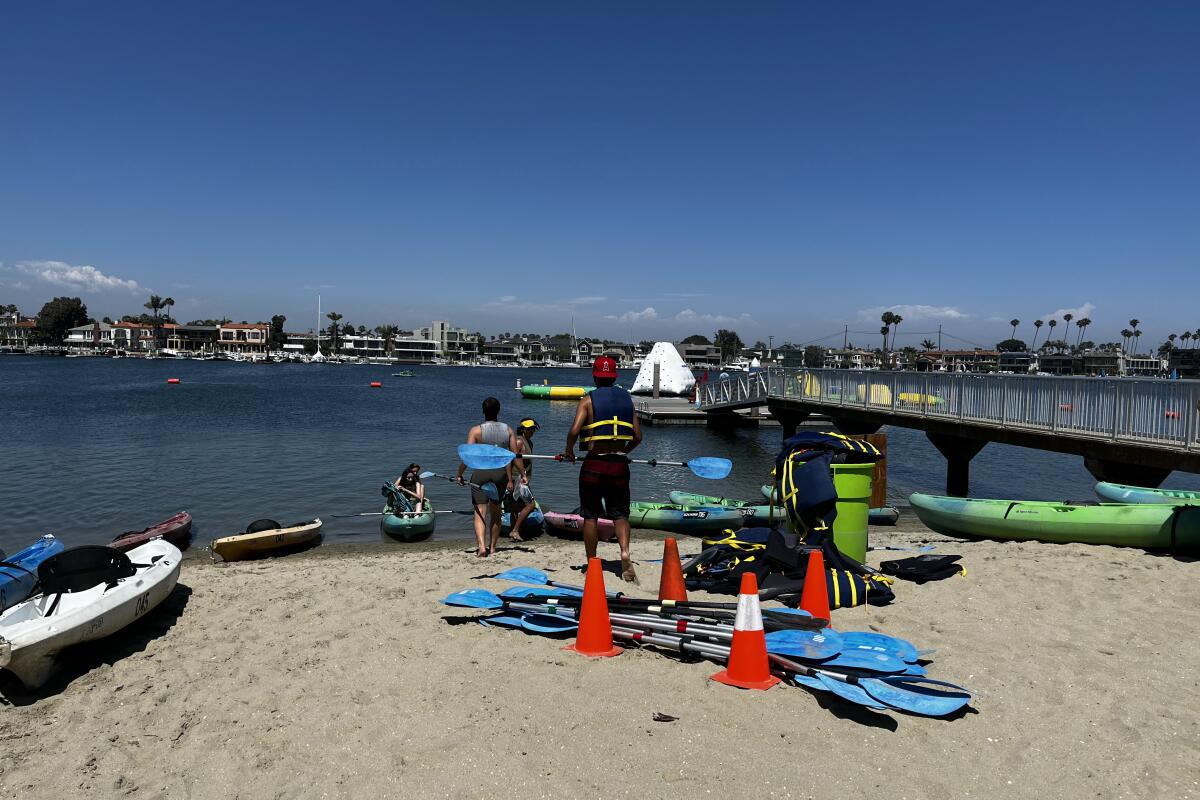 Kayakers get ready to hit the water on Alamitos Bay.