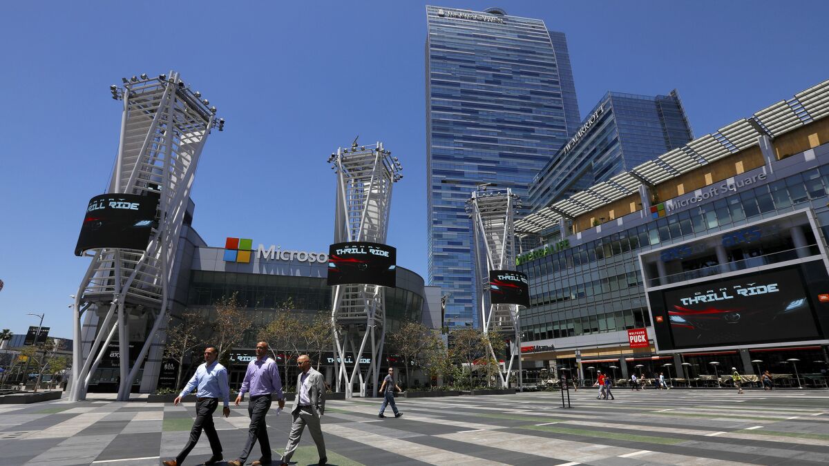 People walk through L.A. Live in Los Angeles during the lunch hour on May 7. There is a $1.2-billion proposal to substantially expand the Los Angeles Convention Center and add a new tower to the JW Marriott hotel, seen in background.