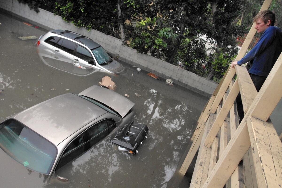 Matthew Wozniak looks at his roommate's submerged car in their parking space at 6417 Franklin Ave. in Hollywood the day a water main broke and flooded the streets.