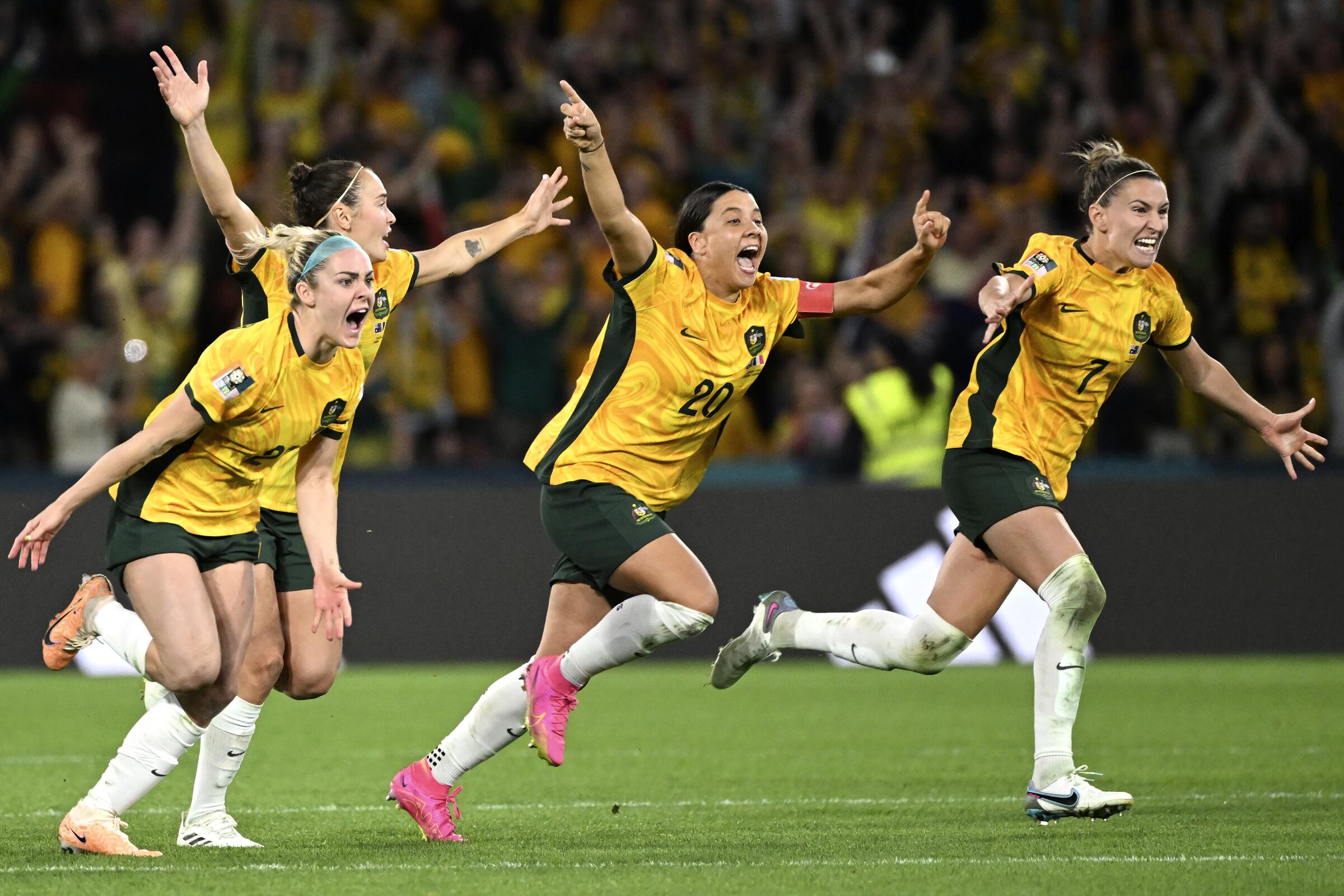 Four Australian women's soccer players celebrate after defeating France