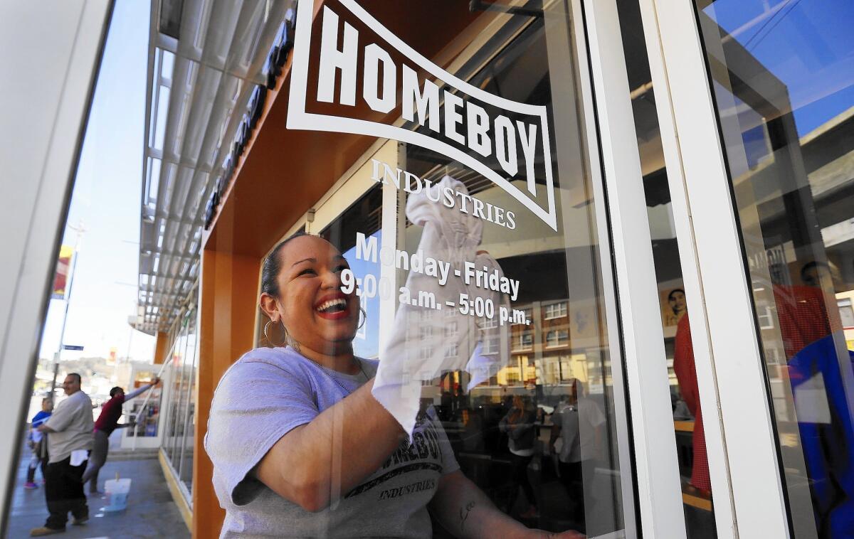 Homeboy Industries is planning to expand into a building next door to its current headquarters in Chinatown, where Ilenee Velasco cleans the front windows.