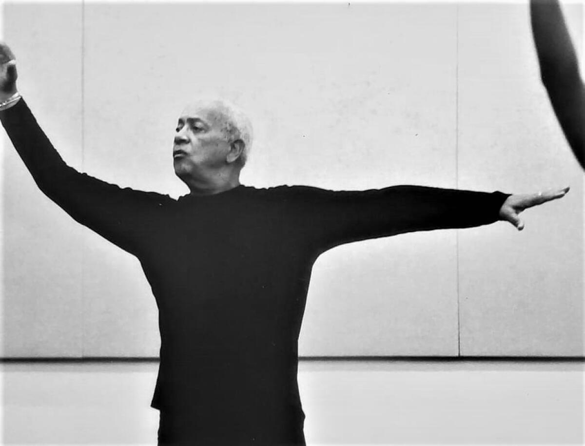 An older man dressed in black demonstrates a Lester Horton modern dance move.