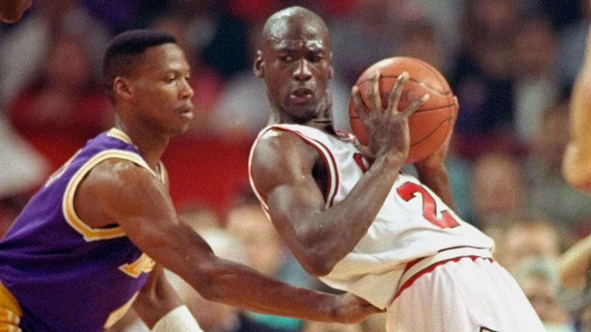 Lakers guard Byron Scott, left, defends against Chicago Bulls star Michael Jordan during a Game 2 of the 1991 NBA Finals.