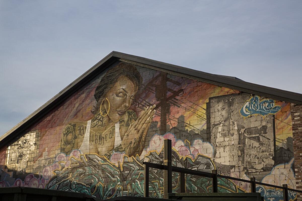 The building will retain some of its original graffiti murals, such as this one, by Else Oner, which features wheat-pasted posters by Jeanette Paredes, in the planting garden.