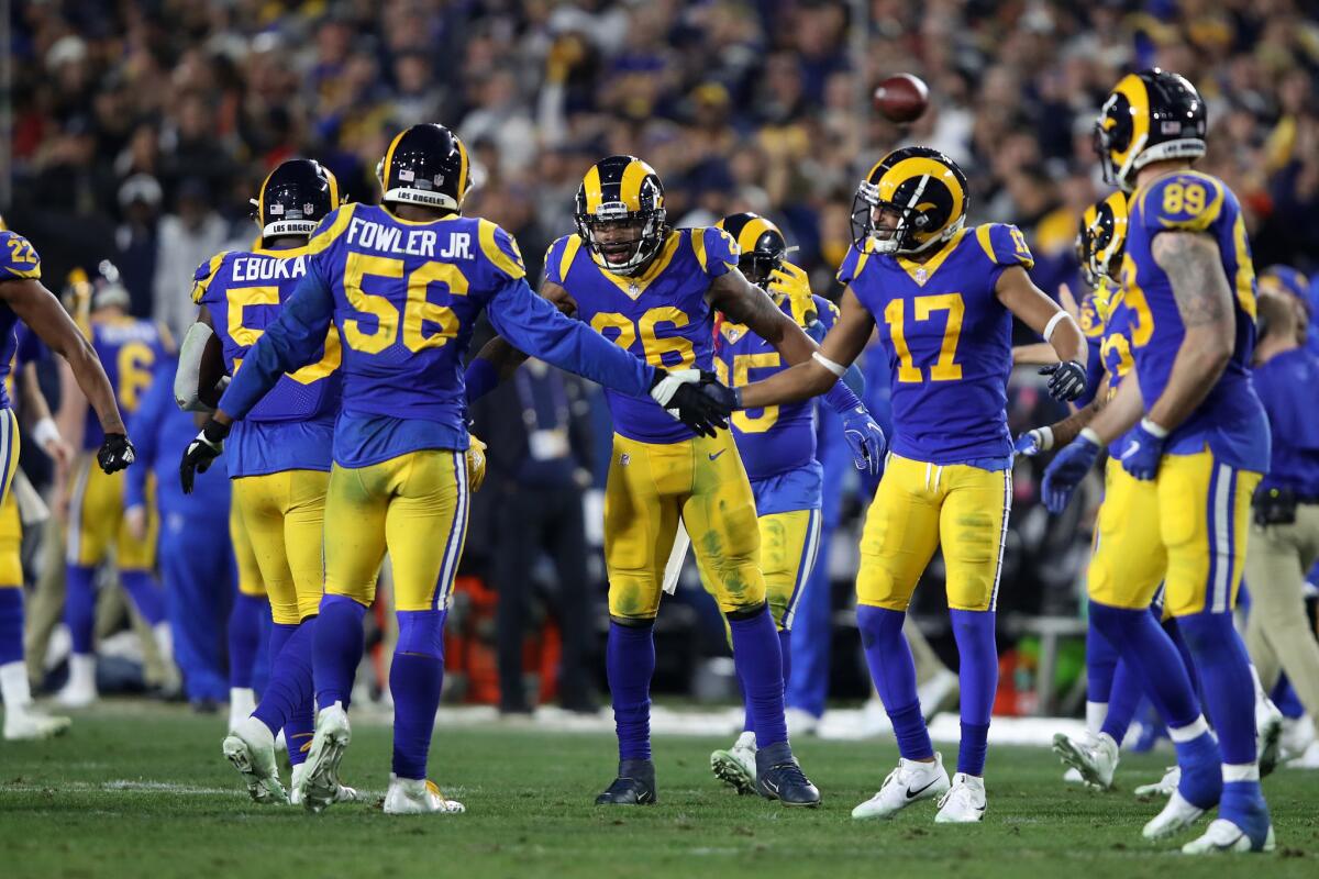 Dante Fowler #56 and Robert Woods #17 of the Los Angeles Rams celebrate after a stop in the second half against the Dallas Cowboys in the NFC Divisional Playoff game at Los Angeles Memorial Coliseum on January 12, 2019 in Los Angeles, California.