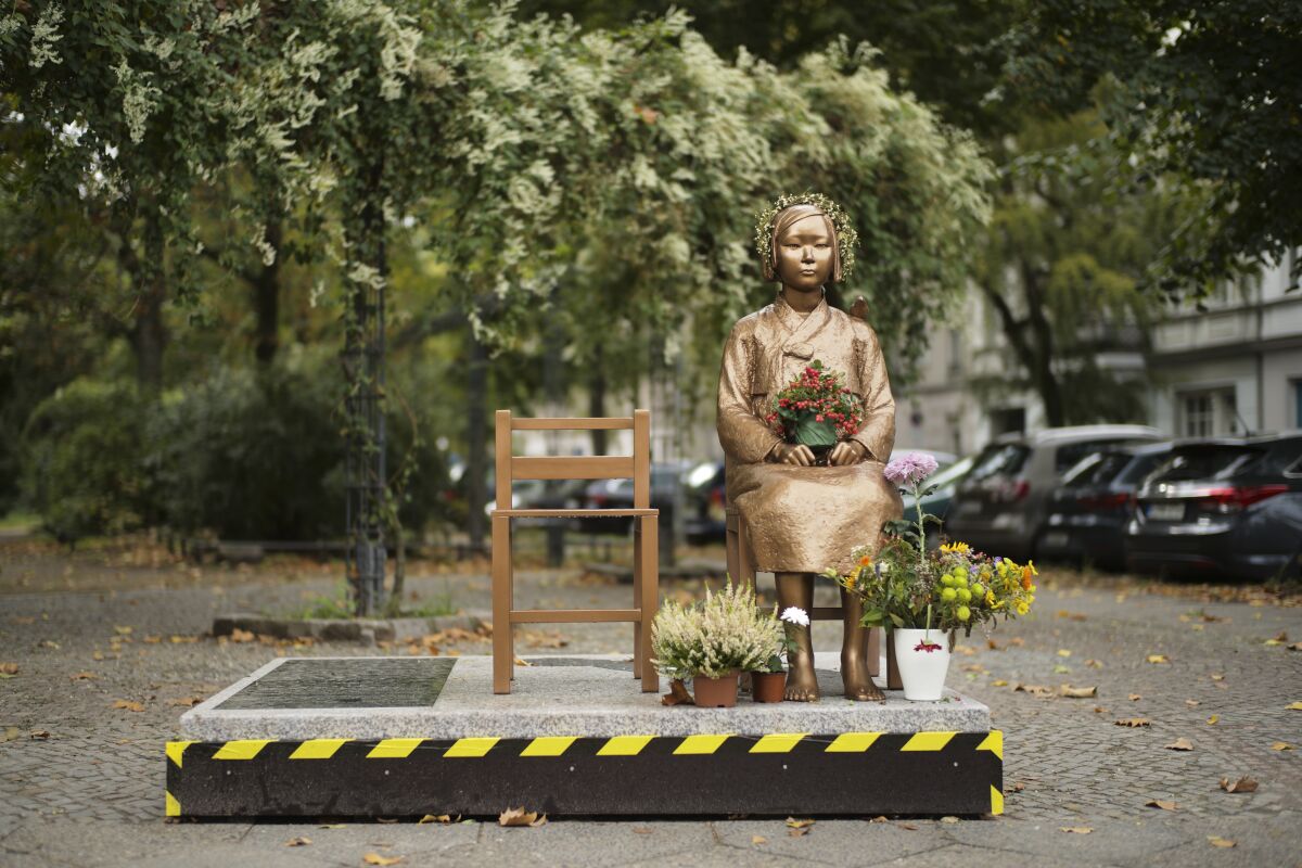 File - In this Friday, Oct. 9, 2020 file photo, a statue commemorating so-called 'comfort women', an euphemism given by Japan to the women and girls enslaved for sex by the Japanese army during World War II, is displayed at a residential area in central Berlin, Germany. This week, Berlin's Mitte district assembly approved a motion urging the local government to let the statue stand and find a solution for its long-term exhibition. (AP Photo/Markus Schreiber)