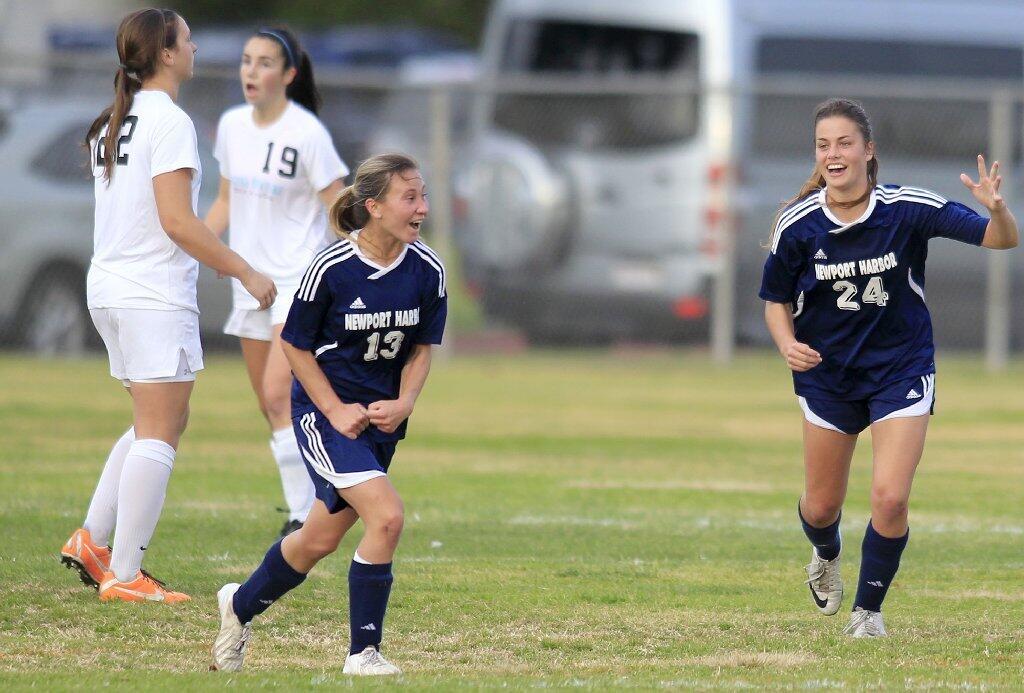 Newport Harbor High's Toni Holland (13) and teammate Sianna Siemonsma (24) react after Holland headed in a corner kick during the second half against Corona del Mar in the Battle of the Bay match on Tuesday.
