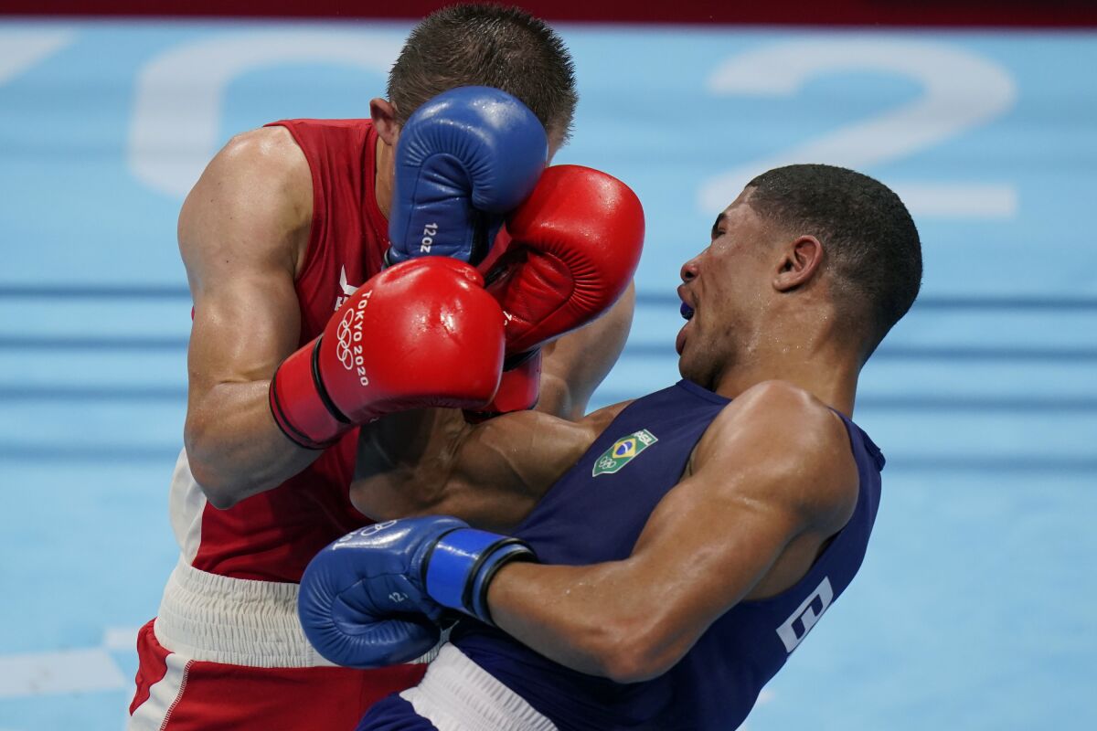 Ukraine's Oleksandr Khyzhniak, left exchanges punches with Brazil's Hebert Sousa during their men's middleweight 75-kg boxing gold medal match at the 2020 Summer Olympics, Saturday, Aug. 7, 2021, in Tokyo, Japan. (AP Photo/Frank Franklin II)