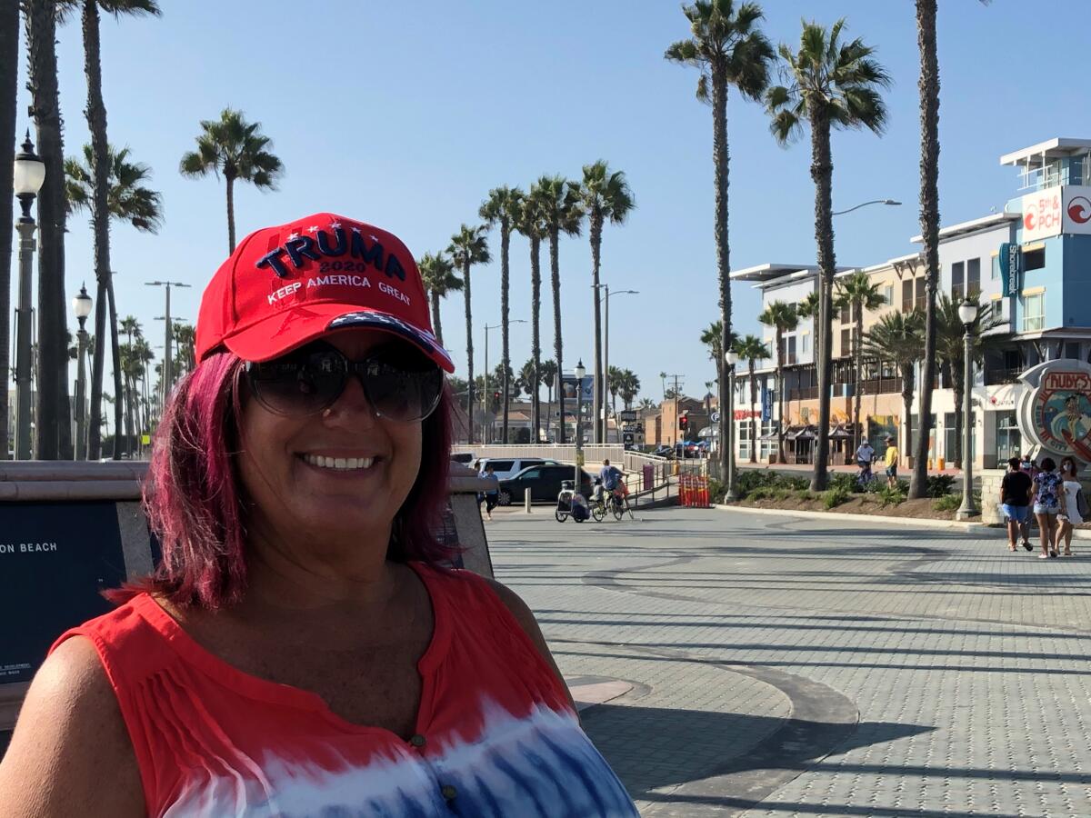 Jeanine Davis poses with a red Trump hat in Huntington Beach.