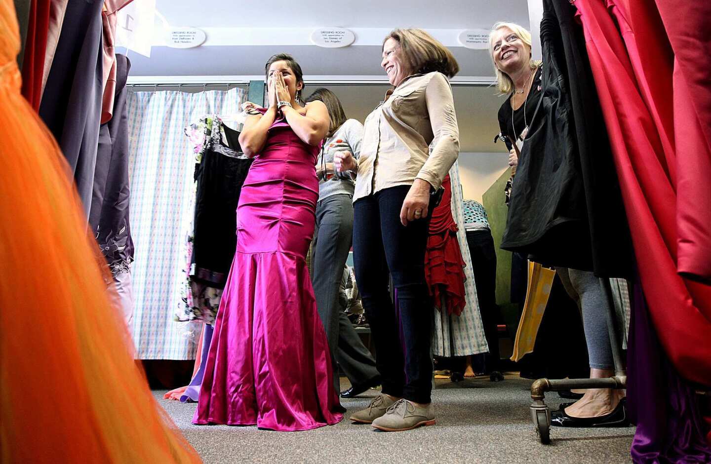Ruby Diaz, 18, left, covers her face in excitement while trying on a prom gown with the help of Linda Levine, center, and Perri Kranzdorf, right, at Operation School Bell-Assistance League of Southern California headquarters in Hollywood. Diaz, a senior at Miguel Contreras Learning Complex in downtown Los Angeles, said, "When my dad recently lost his job, I wasn't thinking I was going to prom, so I'm very thankful for this program....It makes me feel wonderful."