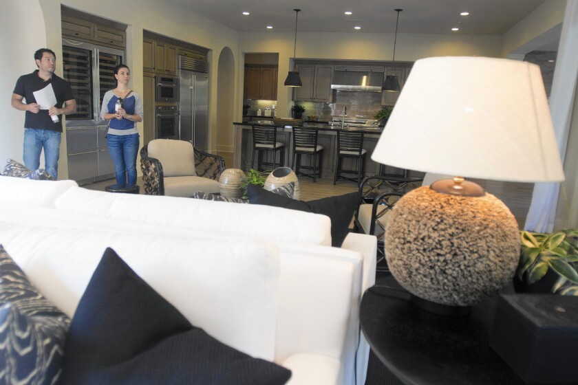 Emerson Tokushiro and his wife, Daniela, look at a model home at Trevi and Amelia luxury homes, which is in Irvine.
