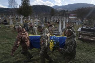 Ukrainian servicemen carry the coffin of their comrade Vasyl Boichuk who was killed in Mykolayiv in March 2022, during his funeral ceremony at the cemetery in Iltsi village, Ukraine, Tuesday, Dec. 26, 2023. (AP Photo/Evgeniy Maloletka)